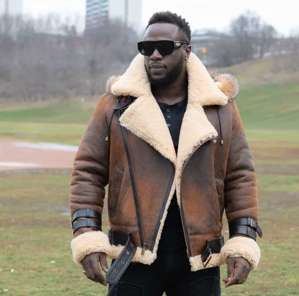 man standing in a park wearing a shearling leather jacket for men