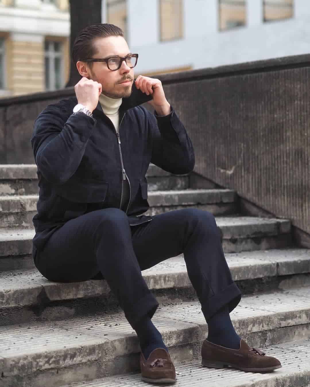 man with glasses sitting on the stairs