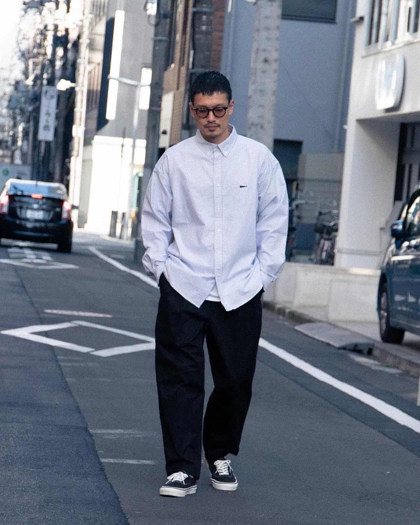 man in an untucked shirt walking the streets