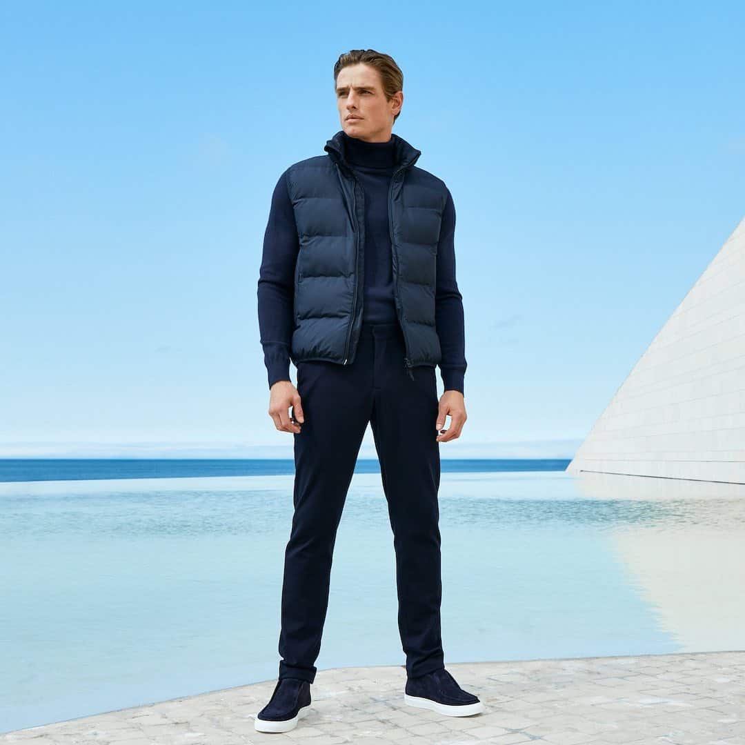 man in a puffer vest standing by the pool