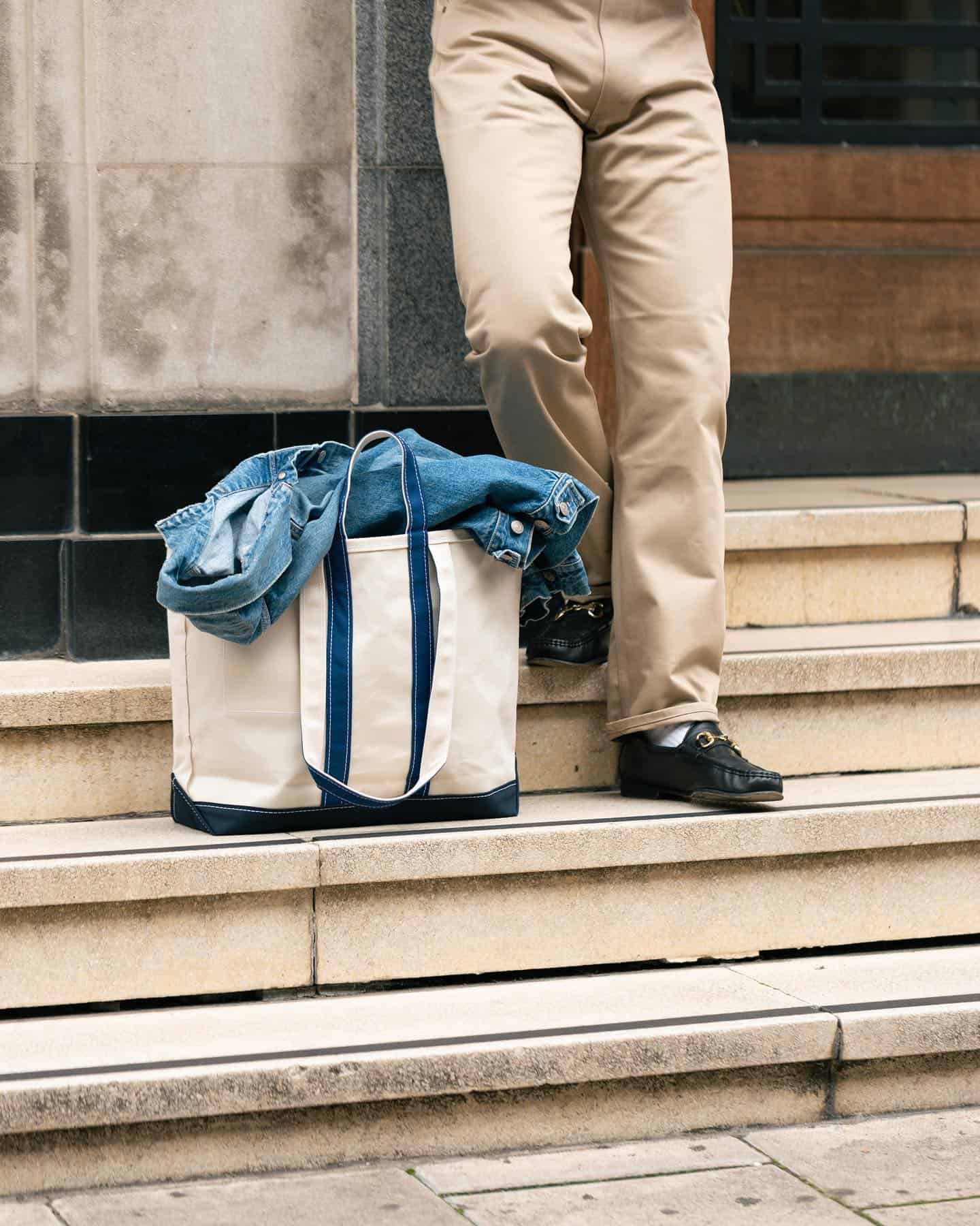 man standing on the stairs beside a tote bag