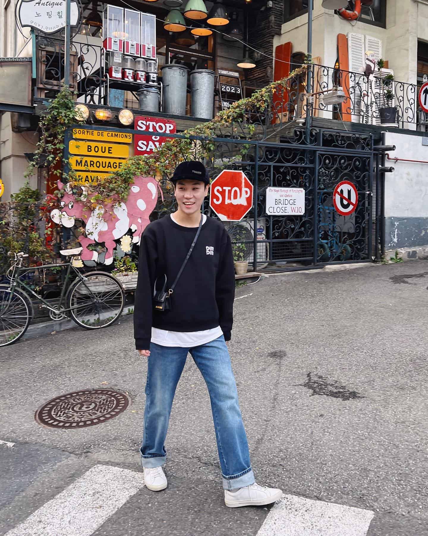 a man with a cross body bag crossing the street