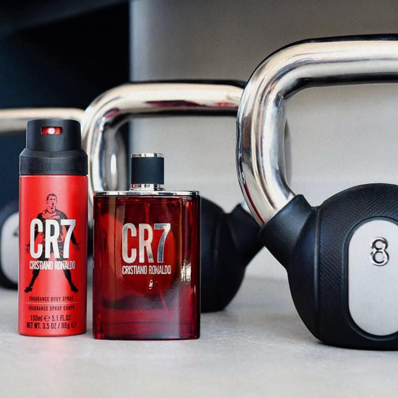 a bottle of CR7 eau de toilette and body spray with kettlebells on the background