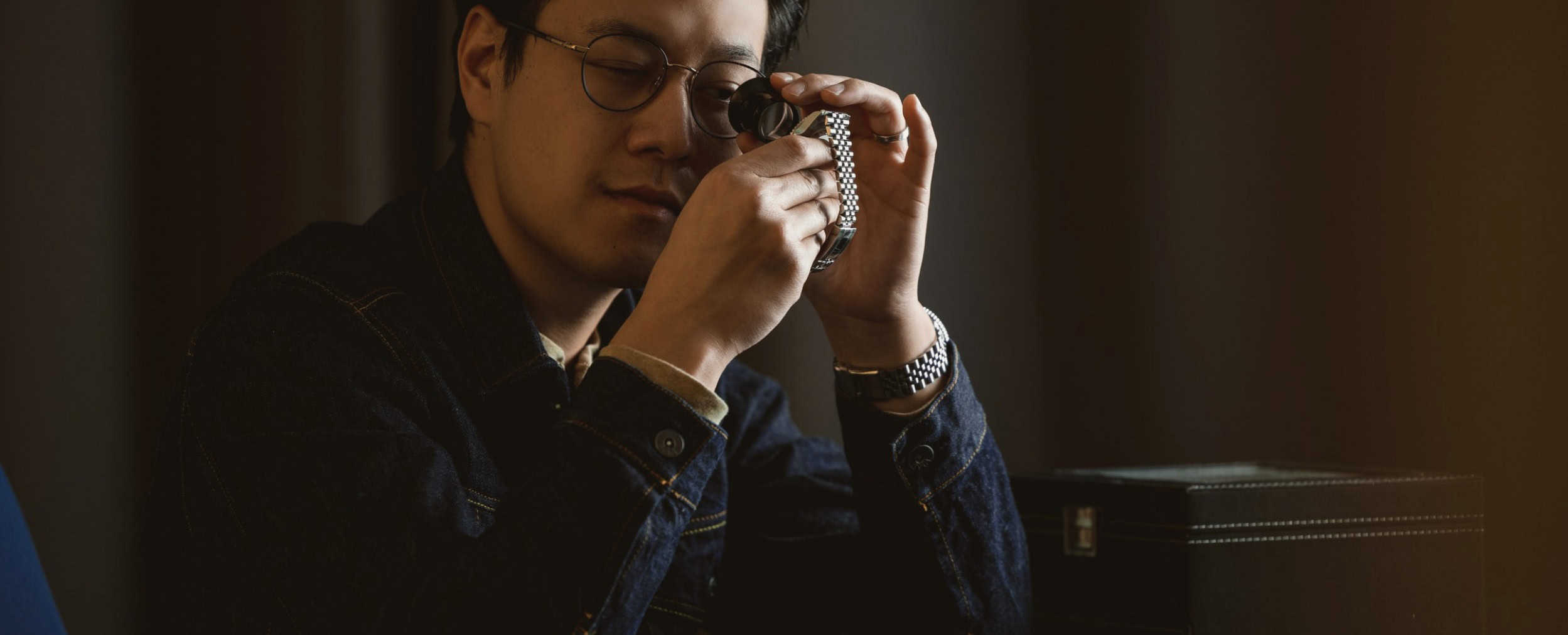 Chris Tran from Clicky Bezel looking at a watch closely in low light