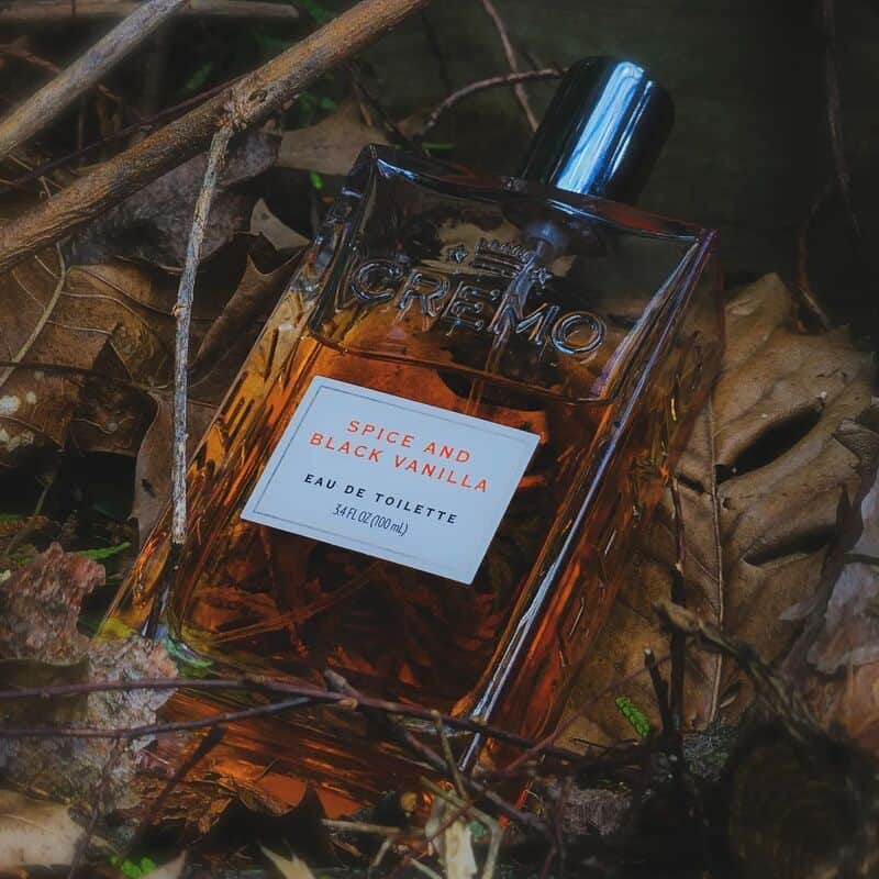 a bottle of Spice and Black Vanilla cologne on top of dry leaves