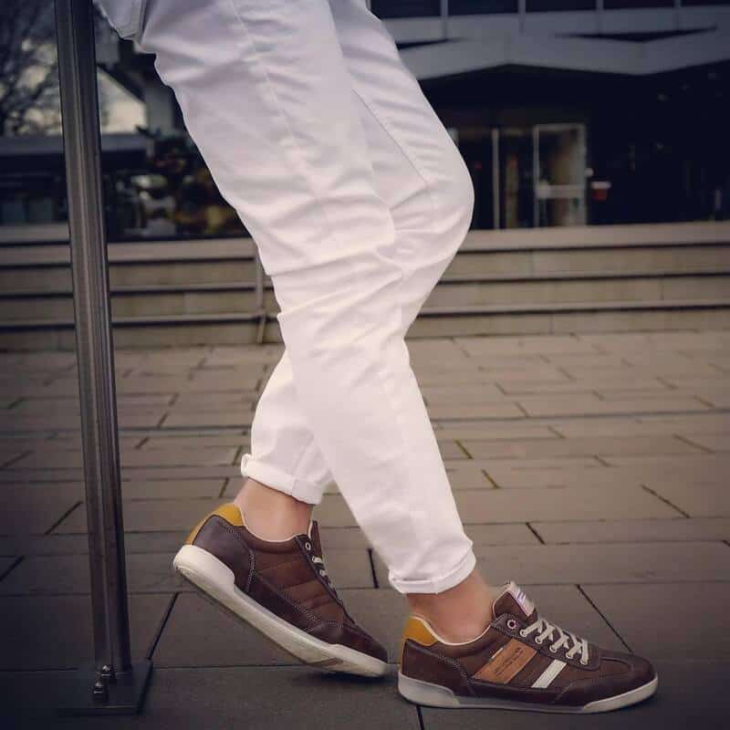 man wearing white pants and brown sneakers by arrigo bello