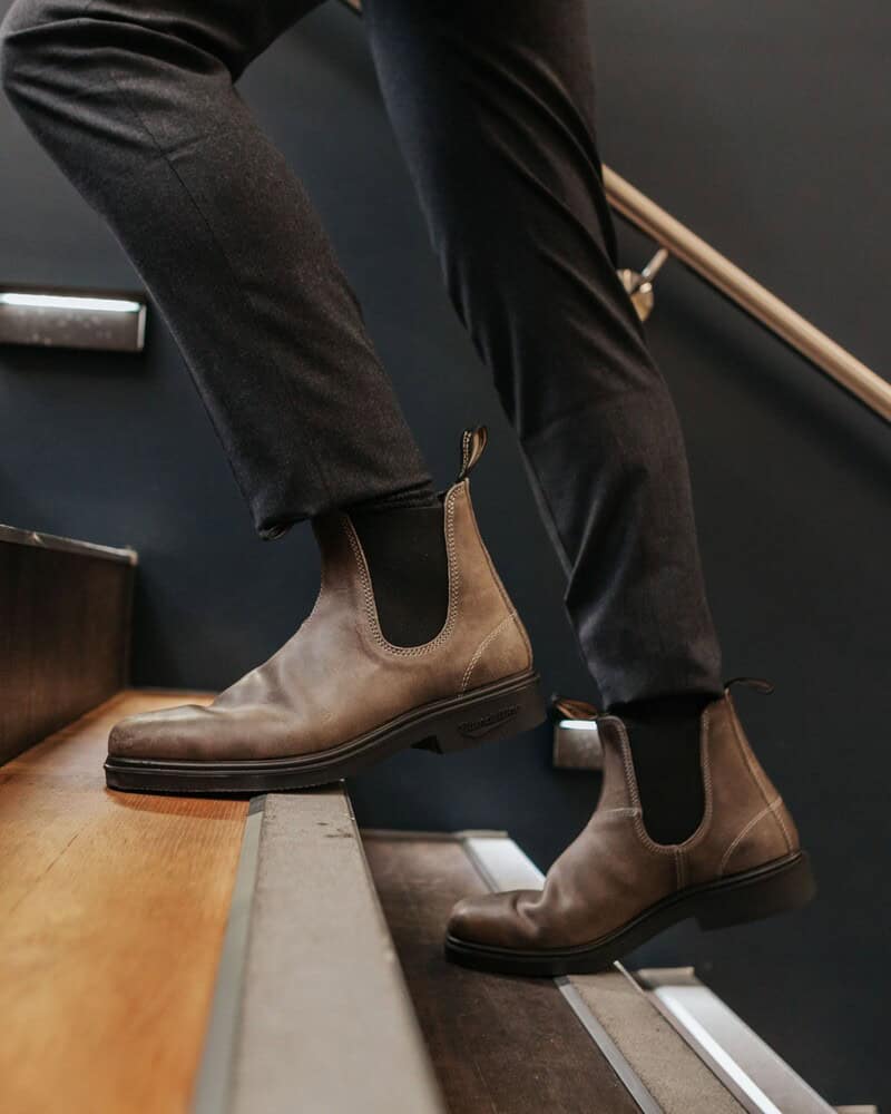 homem subindo escadas usando botas chelsea blundstone