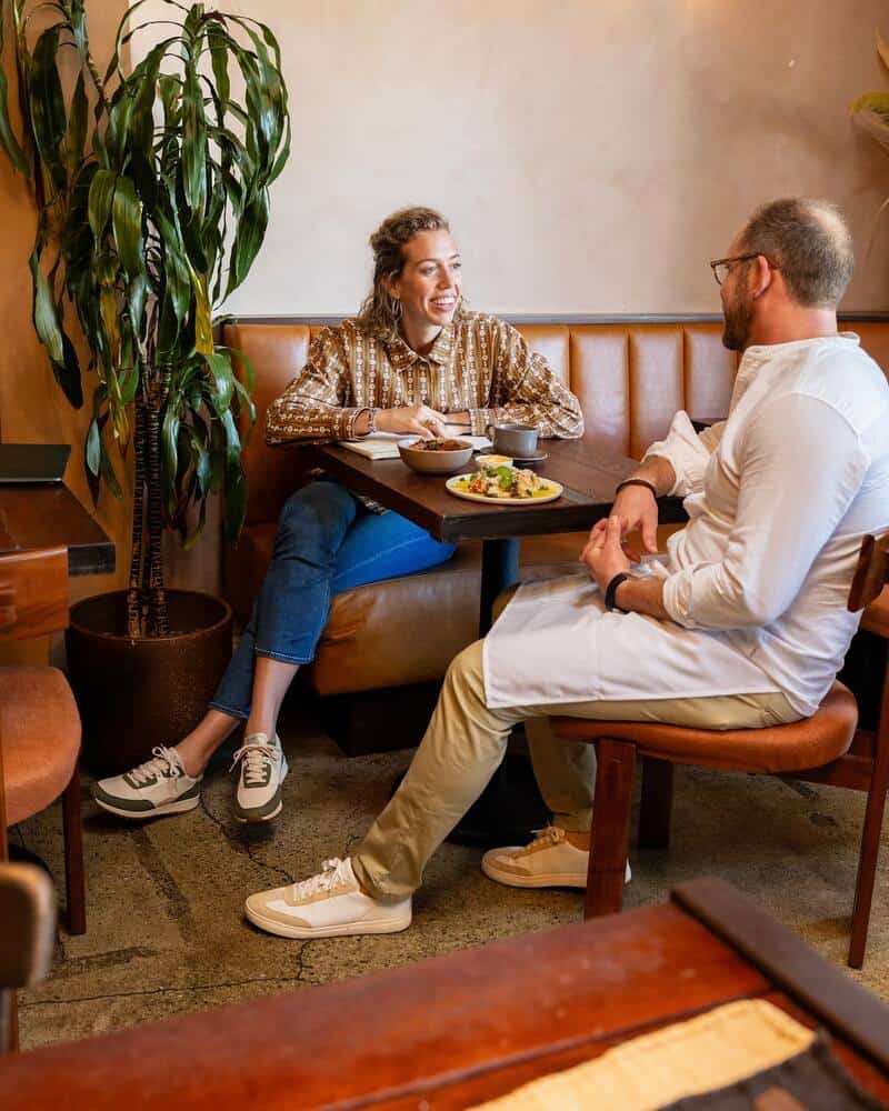 man and woman talking over a meal in a diner