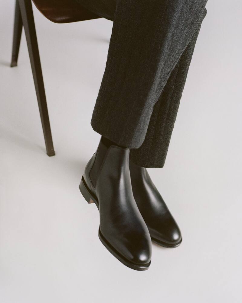 man sitting on a chair wearing the lawry boots by John Lobb