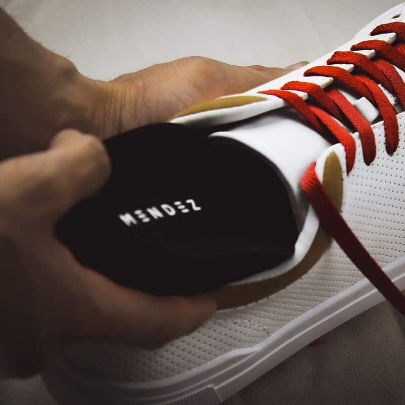 man inserting a mendez insole in a shoe