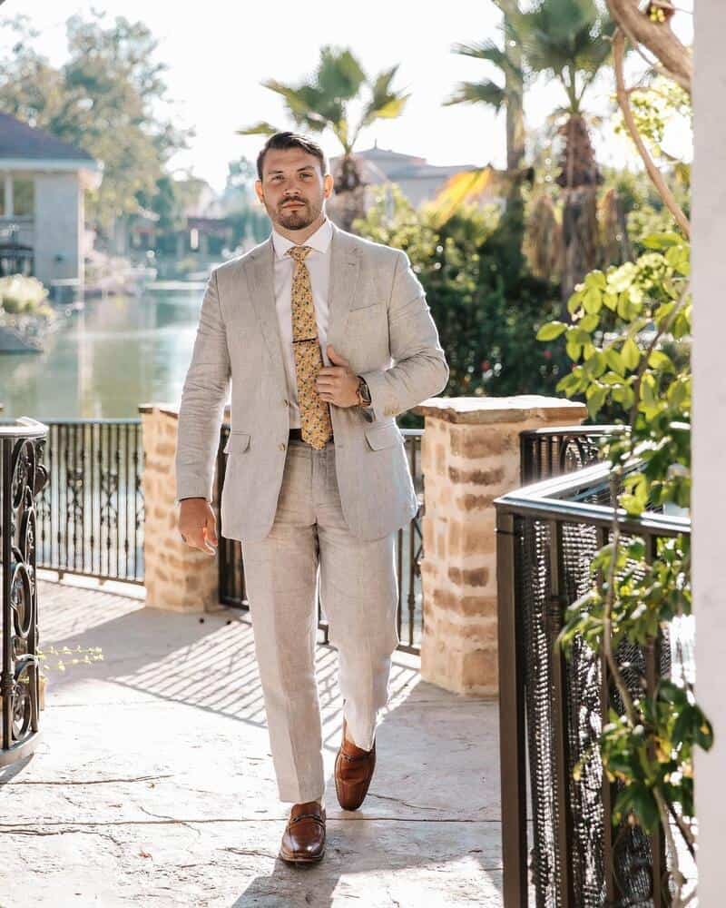 man walking in a tan suit and brown shoes