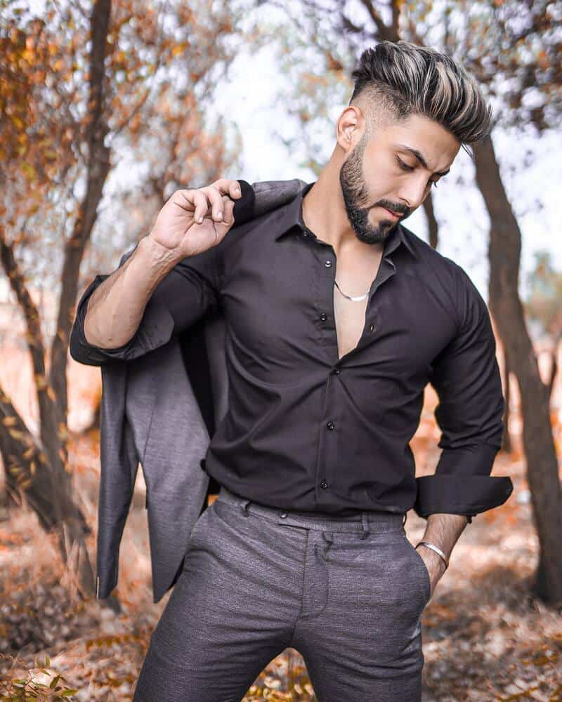 man with tapered hairstyle carrying suit jacket over his shoulder