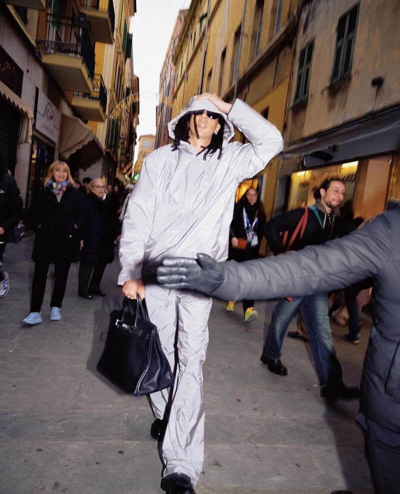 man holding down the hood of a white light jacket