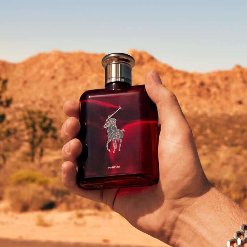 man holding a bottle of polo red cologne