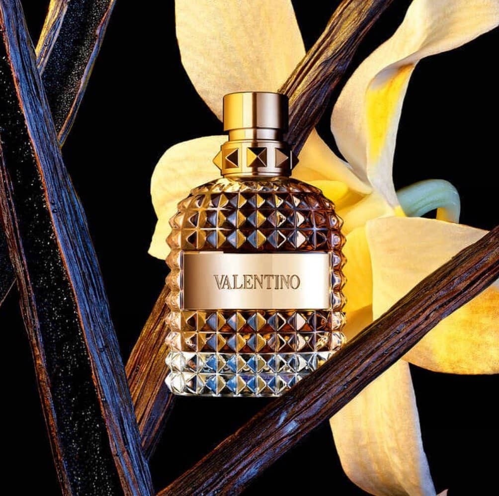a bottle of valentino oumo with a yellow flower background