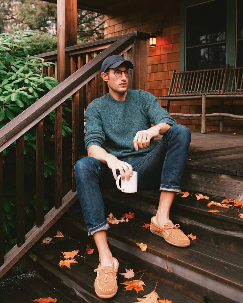 man sitting on stairs wearing the minnetonka moccasin